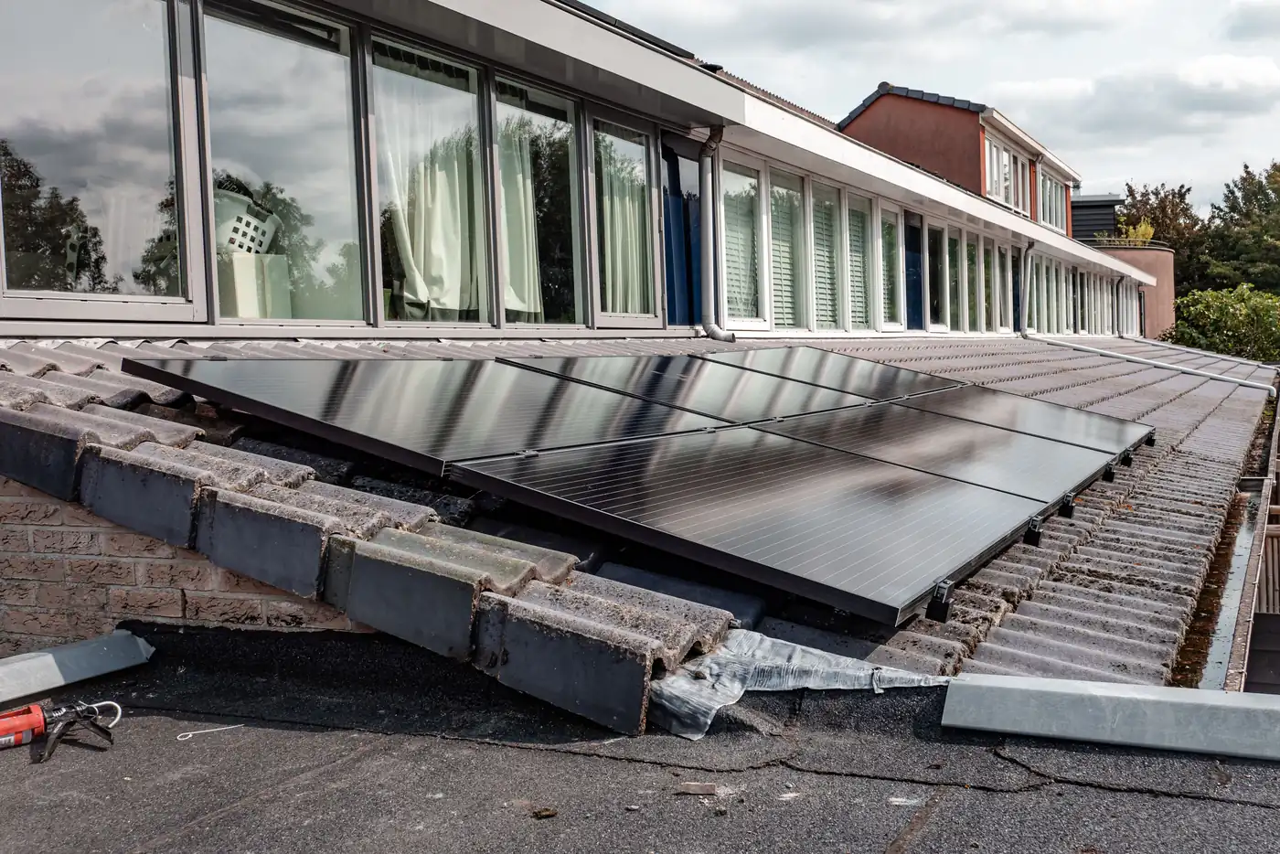 Mit Betonsteinen beschwerte Solarmodule auf dem Flachdach eines modernen Wohnhauses (Langenhagen, Region Hannover)