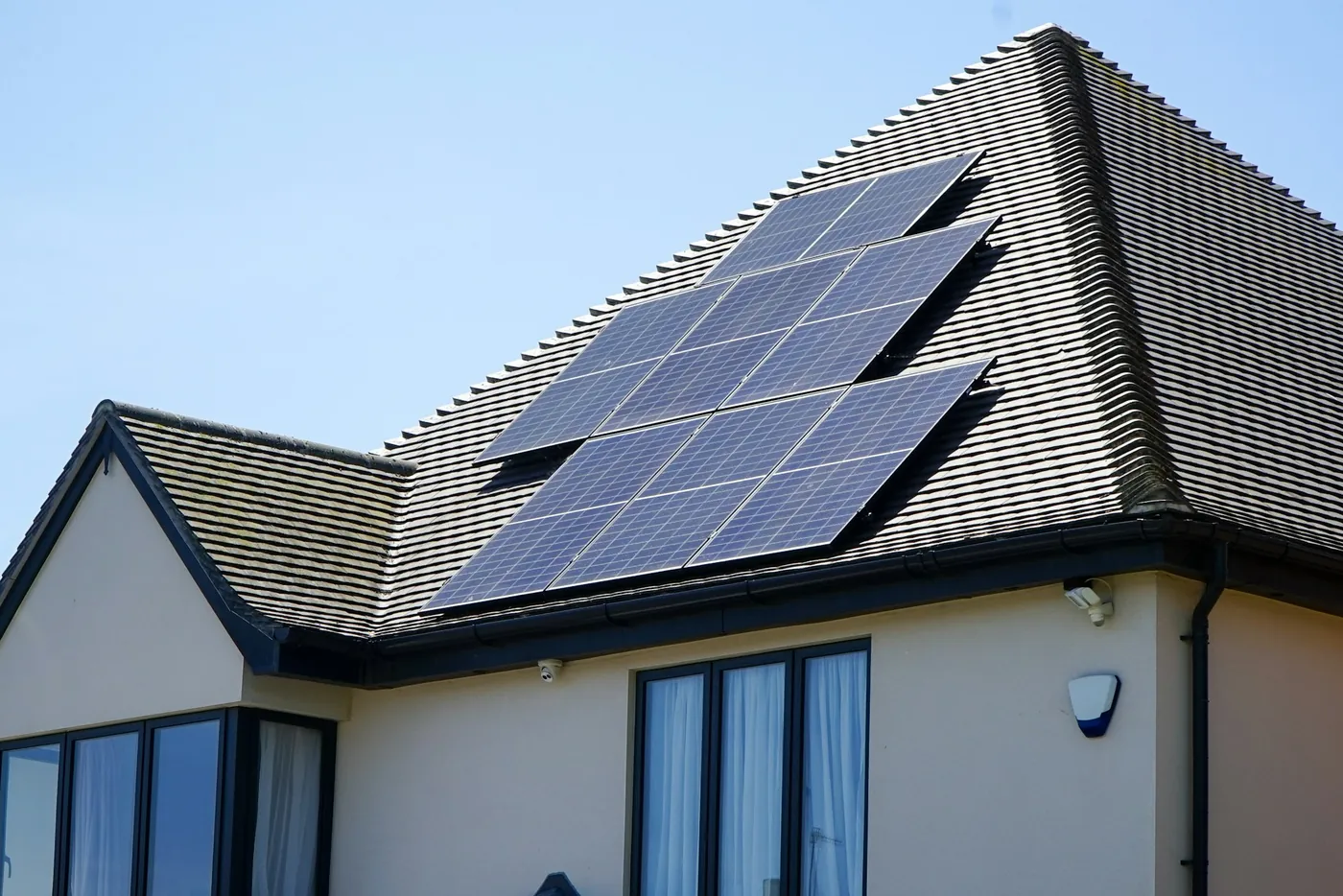 Einfamilienhaus mit weißem Putz und Solarmodulen auf dem dunklen Walmdach (Eschweiler, Städteregion Aachen)