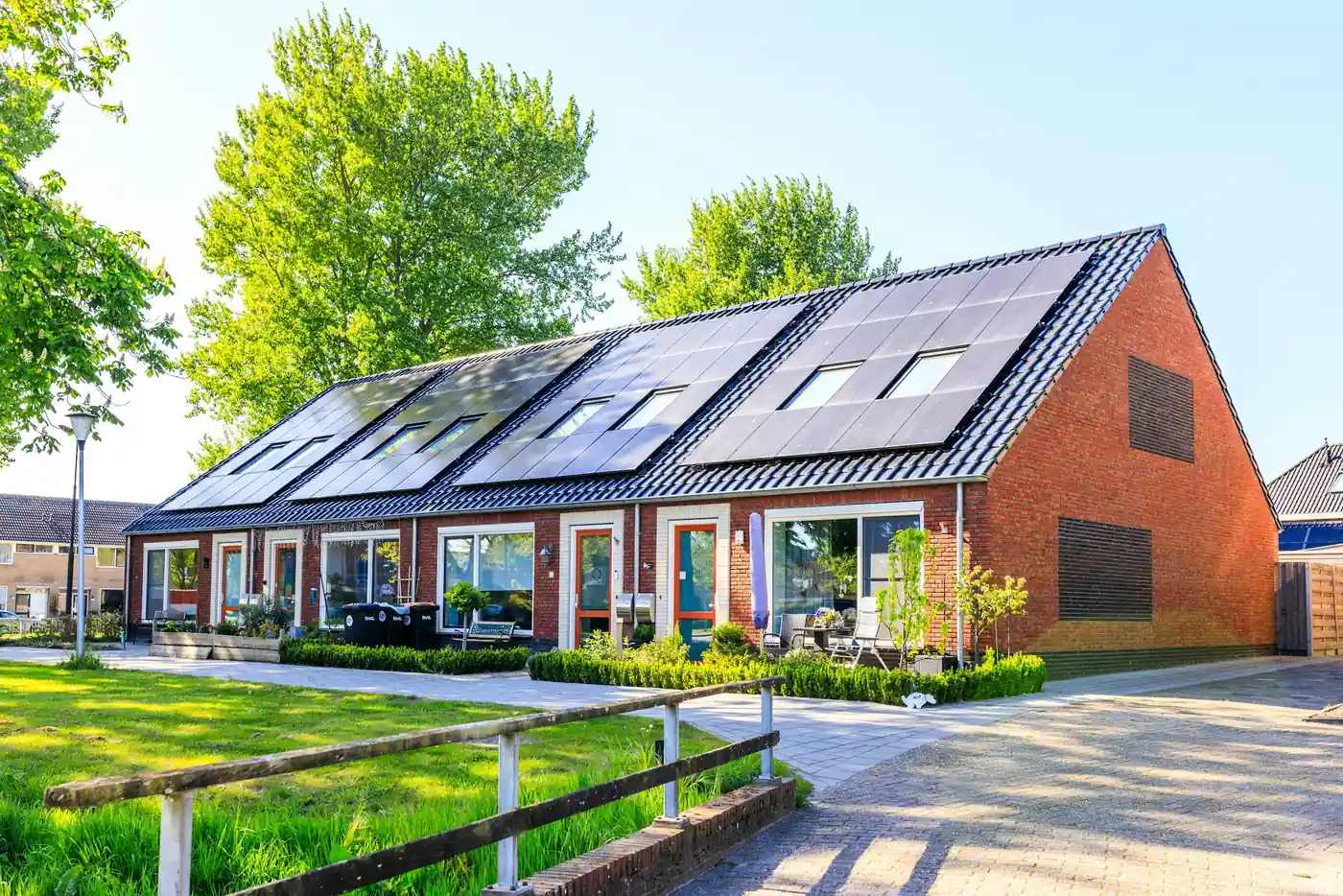Backstein-Reihenhäuser mit Solarmodulen und Dachfenstern auf den Dächern einer Wohnsiedlung (Zandt, Landkreis Cham)